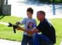 Devon Wallace of Osawatomie mans the fire hose with the help of Osawatomie fire fighter Rusty Thomas Saturday morning at the fire station's open house.